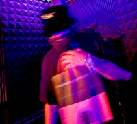 Alternative pop artist Nevv Evve captured in cinematic motion blur while performing inside a neon-lit luxury recording studio during an immersive vocal session.