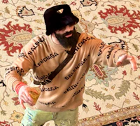 Nevv Evve wearing a Balenciaga sweater and a Prada bucket hat while developing custom songwriting concepts and artistic direction for a personalized music creation experience.