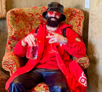 Alternative pop artist Nevv Evve wearing luxury designer attire while discussing creative ideas and personalized songwriting concepts during a custom song consultation experience.
